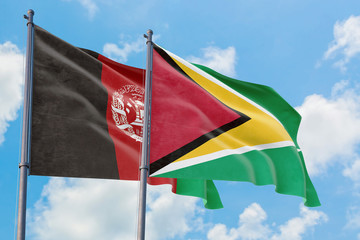 Guyana and Afghanistan flags waving in the wind against white cloudy blue sky together. Diplomacy concept, international relations.