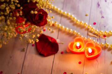 two red burning burning candles hearts flowers bow close up pearls