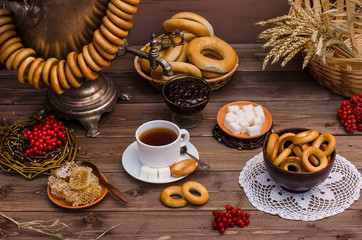 Russian tea. Tea ceremony with a samovar. Cup of tea with jam, bagels on a dark wooden background. Spring, Shrovetide.