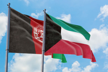 Kuwait and Afghanistan flags waving in the wind against white cloudy blue sky together. Diplomacy concept, international relations.