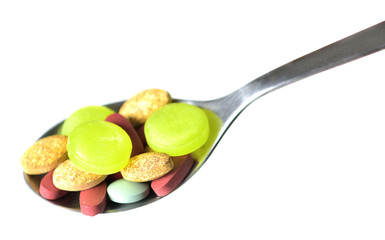 Spoon full of pills and tablets of vitamins, minerals, medicines and other dietary supplements isolated on white background
