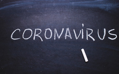 Inscription coronavirus on chalk board.