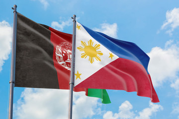 Philippines and Afghanistan flags waving in the wind against white cloudy blue sky together. Diplomacy concept, international relations.