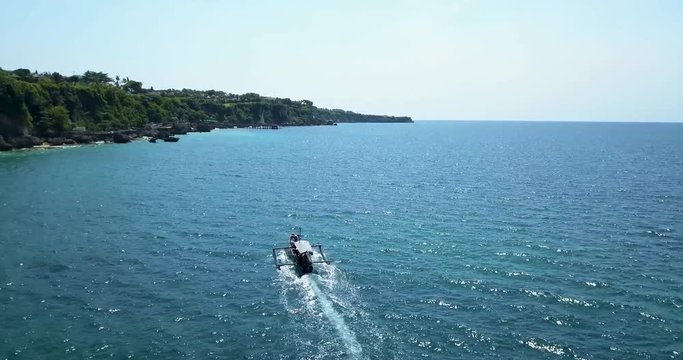 4K Aerial footage of boat sailing in Bali Bay. Drone chasing boat in bay