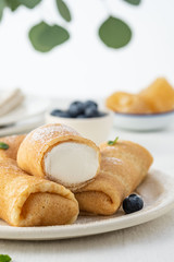 Crepes, thin pancakes with cream cheese and fresh blueberries.