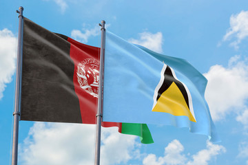 Saint Lucia and Afghanistan flags waving in the wind against white cloudy blue sky together. Diplomacy concept, international relations.