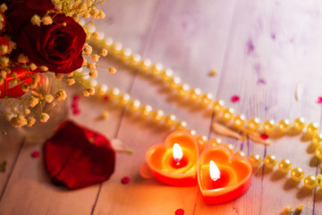 two red burning burning candles hearts flowers bow close up pearls