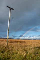 Fototapeta na wymiar Northern Scottish Landscape with Telegraph Pole and Rainbow