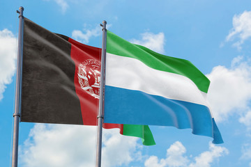 Sierra Leone and Afghanistan flags waving in the wind against white cloudy blue sky together. Diplomacy concept, international relations.