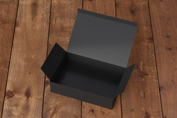 Blank black wide flat box with opened hinged flap lid on dark wooden background. Clipping path around box mock up. 3d illustration