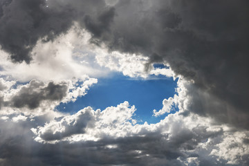 through the thunderclouds visible part of the clear daytime blue sky