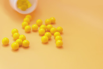 Yellow pills, vitamin C on a yellow background copy space. Concept of medicine, health and body care