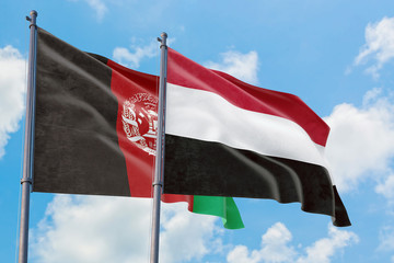 Yemen and Afghanistan flags waving in the wind against white cloudy blue sky together. Diplomacy concept, international relations.