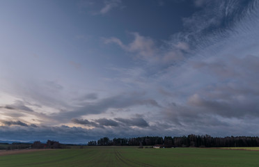 Fototapeta na wymiar Color sunrise on green field near Vyhen village in south Bohemia
