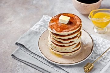 Healthy and delicious breakfast: coffee and stack of classic american pancakes with butter and honey