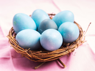 Fototapeta na wymiar Easter greeting card with blue eggs on pink table
