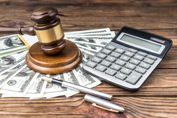 Judge's hammer, money dollars, calculator. Concept taxes, sue money, court