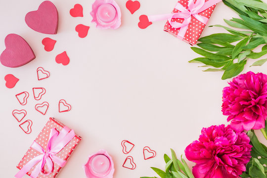 Flat lay valentines day frame with red peonies and gift box on a color background