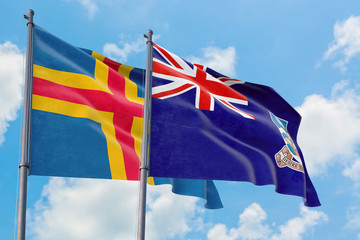 Falkland Islands and Aland Islands flags waving in the wind against white cloudy blue sky together. Diplomacy concept, international relations.