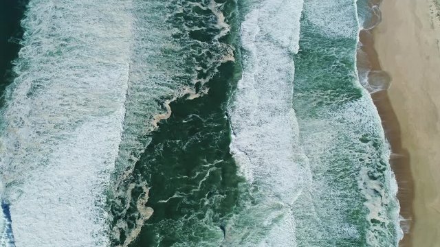 Aerial view of ocean waves and beautiful beach in Portugal, tilt view 4k