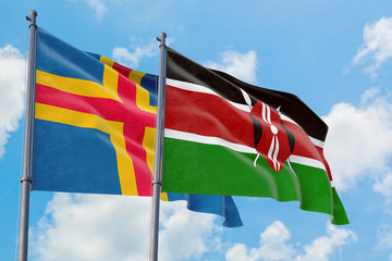 Kenya and Aland Islands flags waving in the wind against white cloudy blue sky together. Diplomacy concept, international relations.