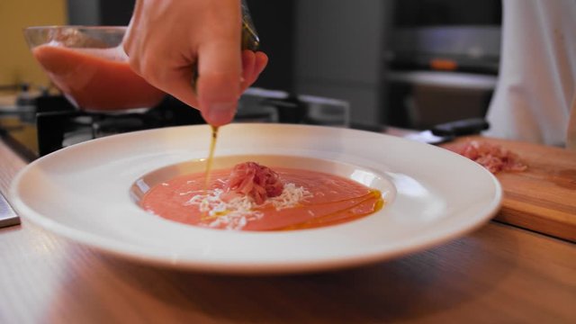 the cook topping gazpacho with oil.