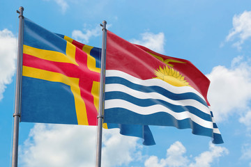 Kiribati and Aland Islands flags waving in the wind against white cloudy blue sky together. Diplomacy concept, international relations.