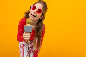 pretty presenter with microphone on yellow background close-up with copy space