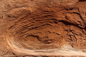 The red barren stone with rough texture that reminds of Mars surface is in reality a brick of an antique building.