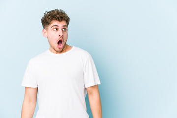 Young blond curly hair caucasian man isolated being shocked because of something she has seen.