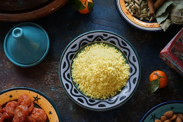 Bulgur porridge in a painted Eastern plate in the center of the table Mandarin dried apricots Eastern cuisine