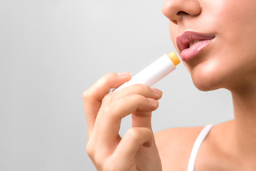 closeup beauty woman lips. applying lip moisturizer. lips protection