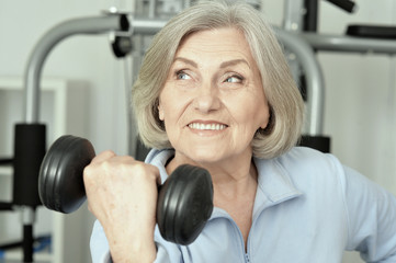 Fototapeta premium Portrait of elderly woman exercising in gym