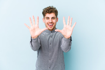 Young blond curly hair caucasian man isolated showing number ten with hands.