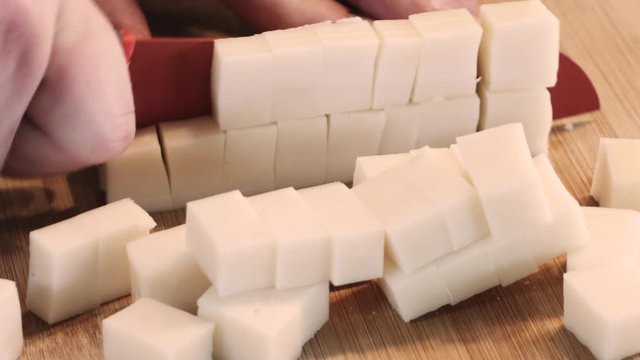 Cutting Mozzarella Cheese Cubes On Wooden Board