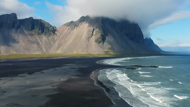 Dolly out of the Vestrahorn, a Mountain next to the ocean in Iceland.