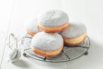 Sweet donuts with powdered sugar on white table