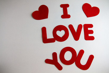 The words I love you, in red felt letters, on a white background.
