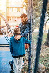 Father and his son enjoying together on basketball court.