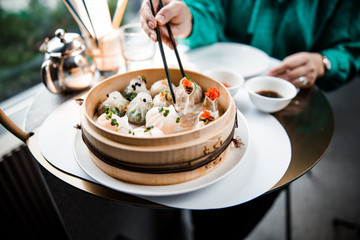 Woman is eating delicious food with chopsticks