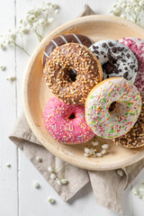 Colorful donuts with various decoration on white plate