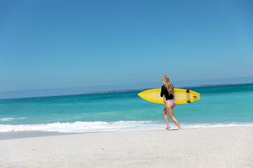 Young woman running with surboard