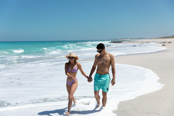 Young couple walking besides the beach