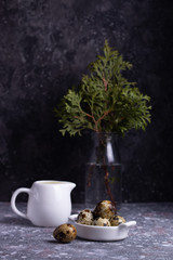 Quail eggs and cream on a dark background