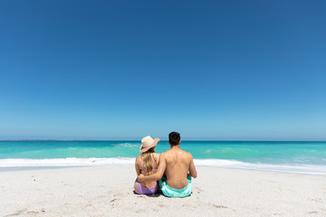 Fototapeta na wymiar Young couple sitting at the beach