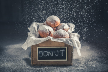 Closeup of tasty mini doughnuts on wooden box