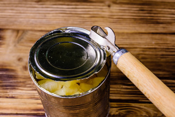 Opening of the aluminium tin can with chopped canned pineapple