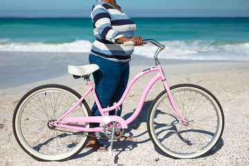 Fototapeta premium Old woman with a bike at the beach