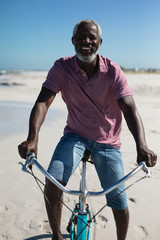 Obraz premium Old man with a bike at the beach