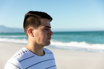 Young man looking the waves from the beach